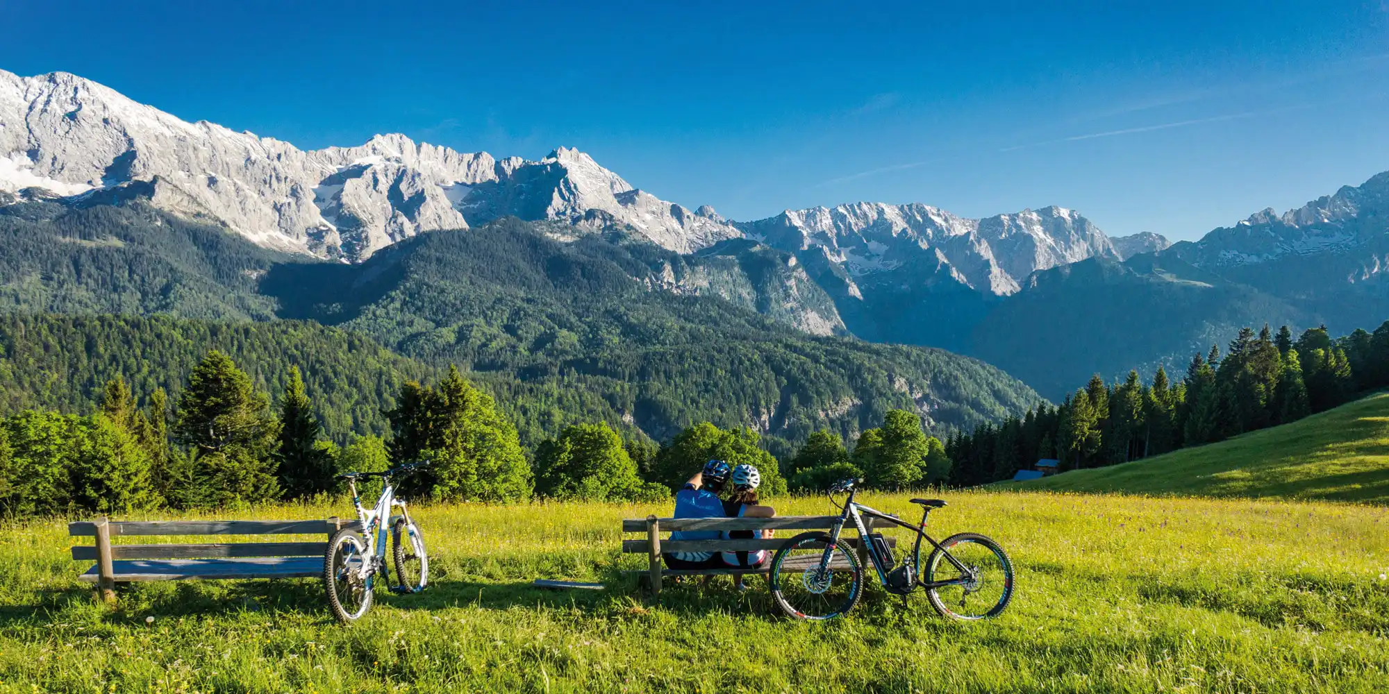 Radfahrer auf Bank mit Blick auf das Karwendelgebirge