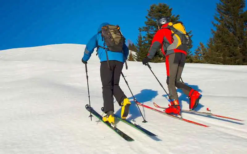 Zwei Skifahrer steigen den Berg hinauf
